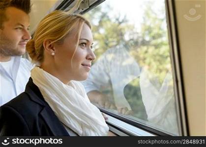 Woman man looking out the train window smiling thinking friends