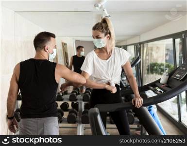 woman man using elbow salute each other gym