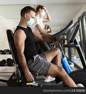 woman man working out gym with medical masks