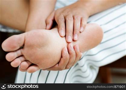 Woman massaging her painful barefoot, healthcare and medical concept