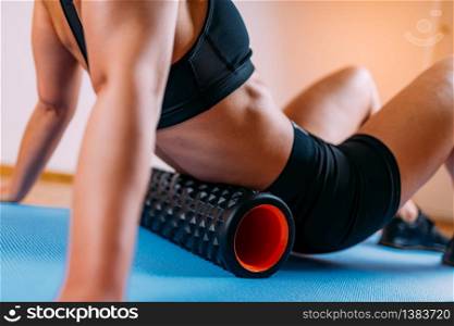 Woman Massaging Lower Back Muscles with Foam Roller at Home. Self Massaging Lower Back Muscles with Foam Roller at Home