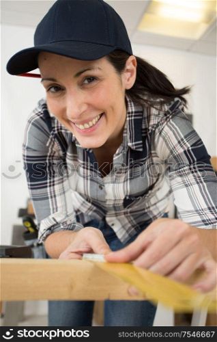 woman measure wood plank before saw