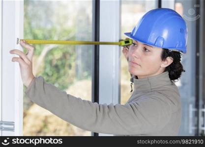 woman measuring a window with tape measure