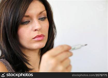 Woman measuring her temperature