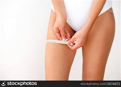Woman measuring her thigh