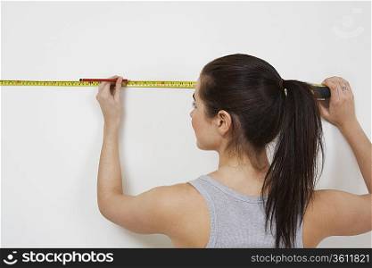 Woman measuring wall