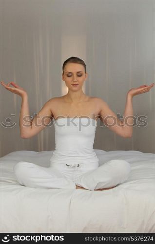 Woman meditating in her bedroom