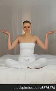 Woman meditating in her bedroom