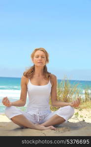 Woman meditating on a beach