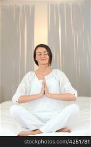 Woman meditating on a bed