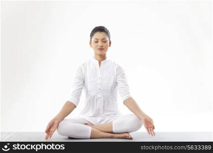 Woman meditating over white background