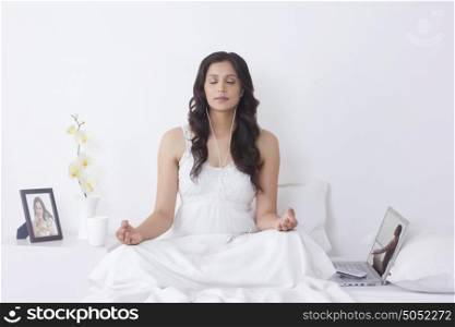 Woman meditating while listening to music