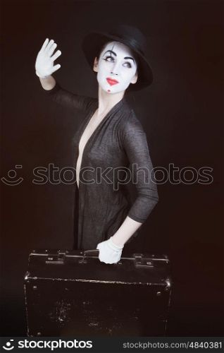 woman mime in hat with suitcase on dark background&#xA;