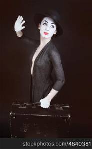 woman mime in hat with suitcase on dark background&#xA;