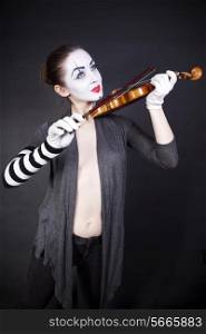 woman mime playing the violin on a black background