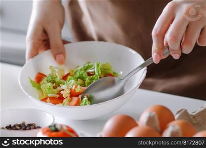 Woman mixes vegetable salad in bowl. Home cooking for healthy diet.. Woman mixes vegetable salad in bowl. Home cooking for a healthy diet.