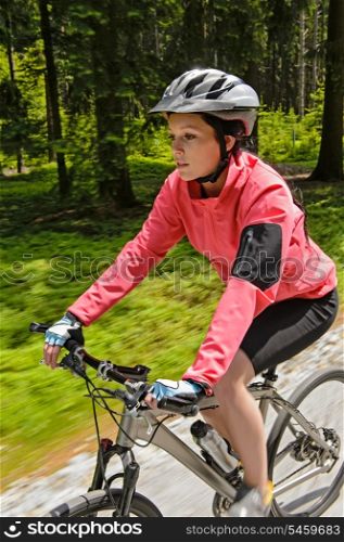 Woman mountain biking in forest motion blur training race