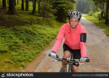Woman mountain biking through forest road blur motion