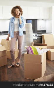 Woman Moving Into New Home Talking On Mobile Phone