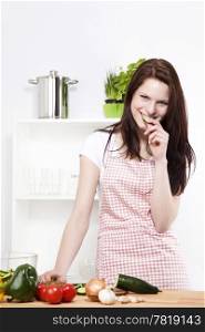 woman nibbling on a cucumber. happy young woman nibbling on a chopped cucumber