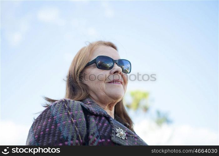 Woman of about sixty years abroad with sunglasses
