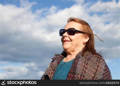 Woman of about sixty years abroad with sunglasses