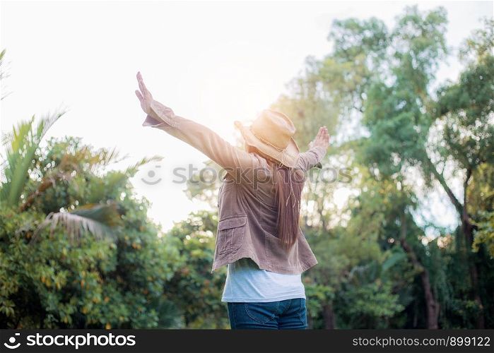 Woman of happiness in forest with the sunlight at sky.