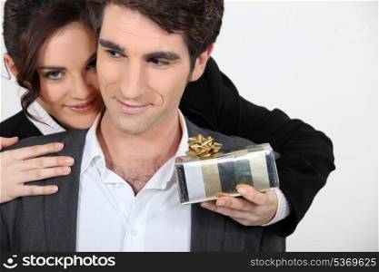 Woman offering man surprise gift