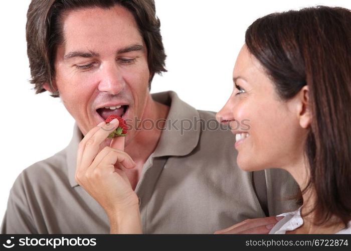 Woman offering piece of fruit to man