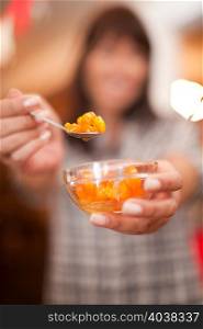 Woman offering spoonful of preserves