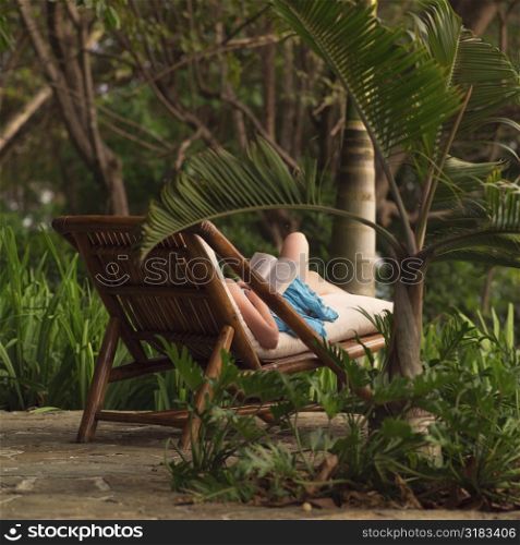 Woman on a lounge chair reading