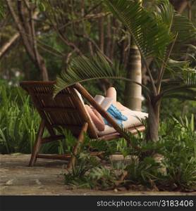 Woman on a lounge chair reading