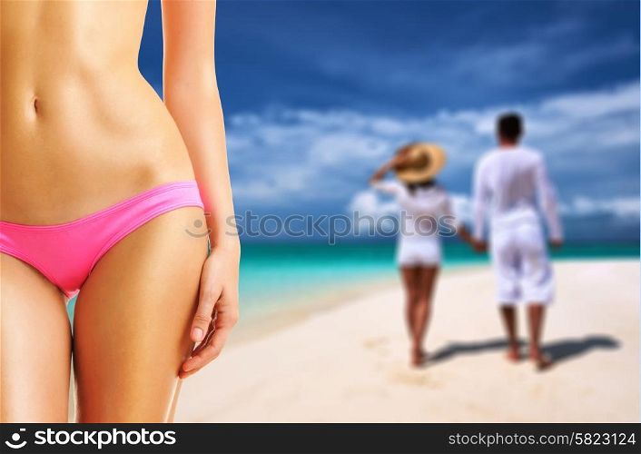 Woman on a tropical beach at Maldives, couple in background. Collage.
