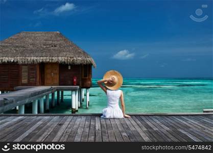 Woman on a tropical beach jetty at Maldives
