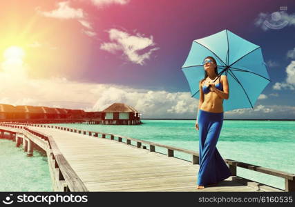 Woman on a tropical beach jetty at Maldives