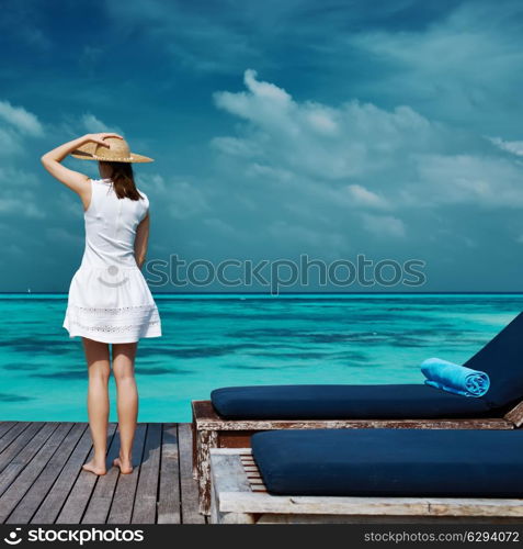 Woman on a tropical beach jetty at Maldives