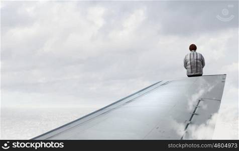 Woman on airplane wing. Middle aged stout woman sitting on edge of aairplane wing