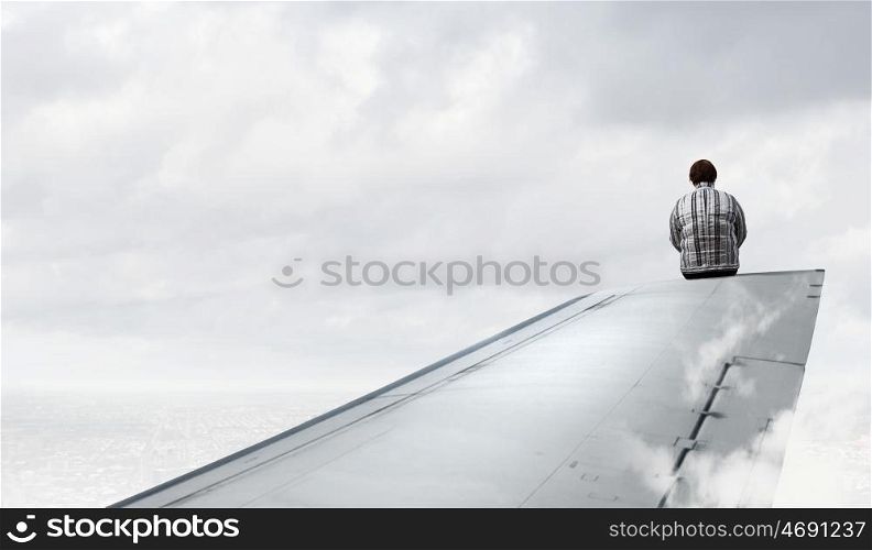 Woman on airplane wing. Middle aged stout woman sitting on edge of aairplane wing