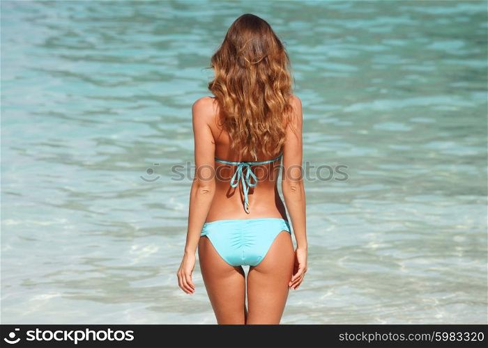 Woman on beach . Woman in bikini standing on ocean beach on hot summer day