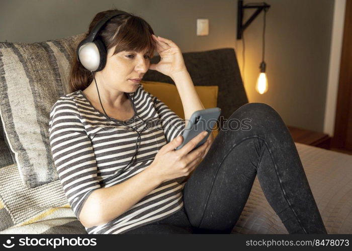Woman on bed at phone with symptoms of depression
