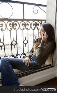 Woman on cell phone in windowsill