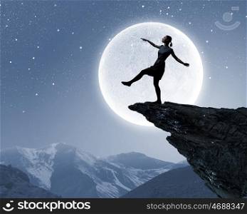 Woman on edge. Silhouette of woman walking on edge of rock