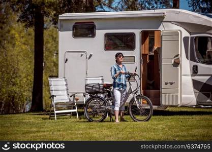 Woman on electric bike resting at the campsite. Family vacation travel, holiday trip in motorhome, VR Caravan car Vacation.