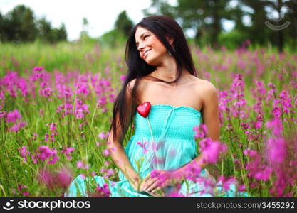 woman on flower field heart in hands