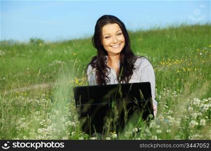 woman on green field work on laptop