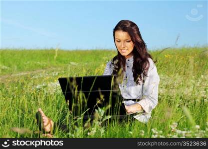 woman on green field work on laptop