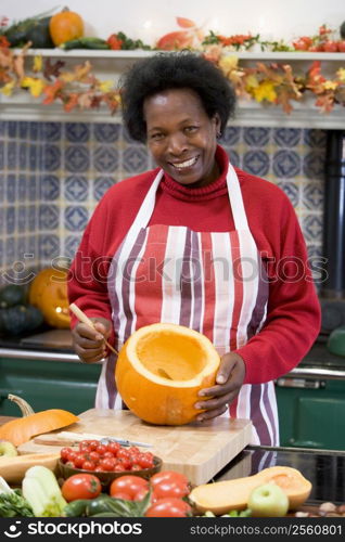 Woman on Halloween making jack o lantern smiling