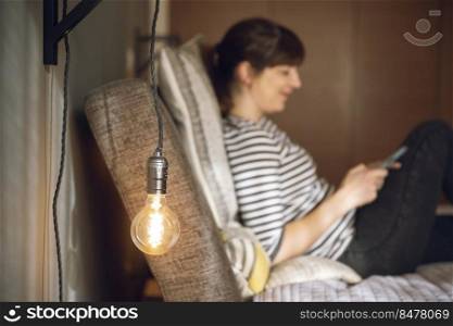 Woman on her bedroom, sending a text message