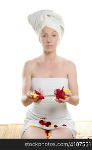 Woman on her knees holding rose colorful petals, bath spa towel