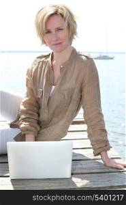 Woman on laptop by the sea